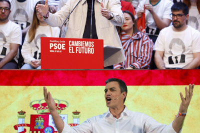 En primera fila, una bandera que nadie esperaba. En el escenario, Sánchez que no mira al azar. Su reacción fue pequeña… y por eso asusta: parecía ensayada.